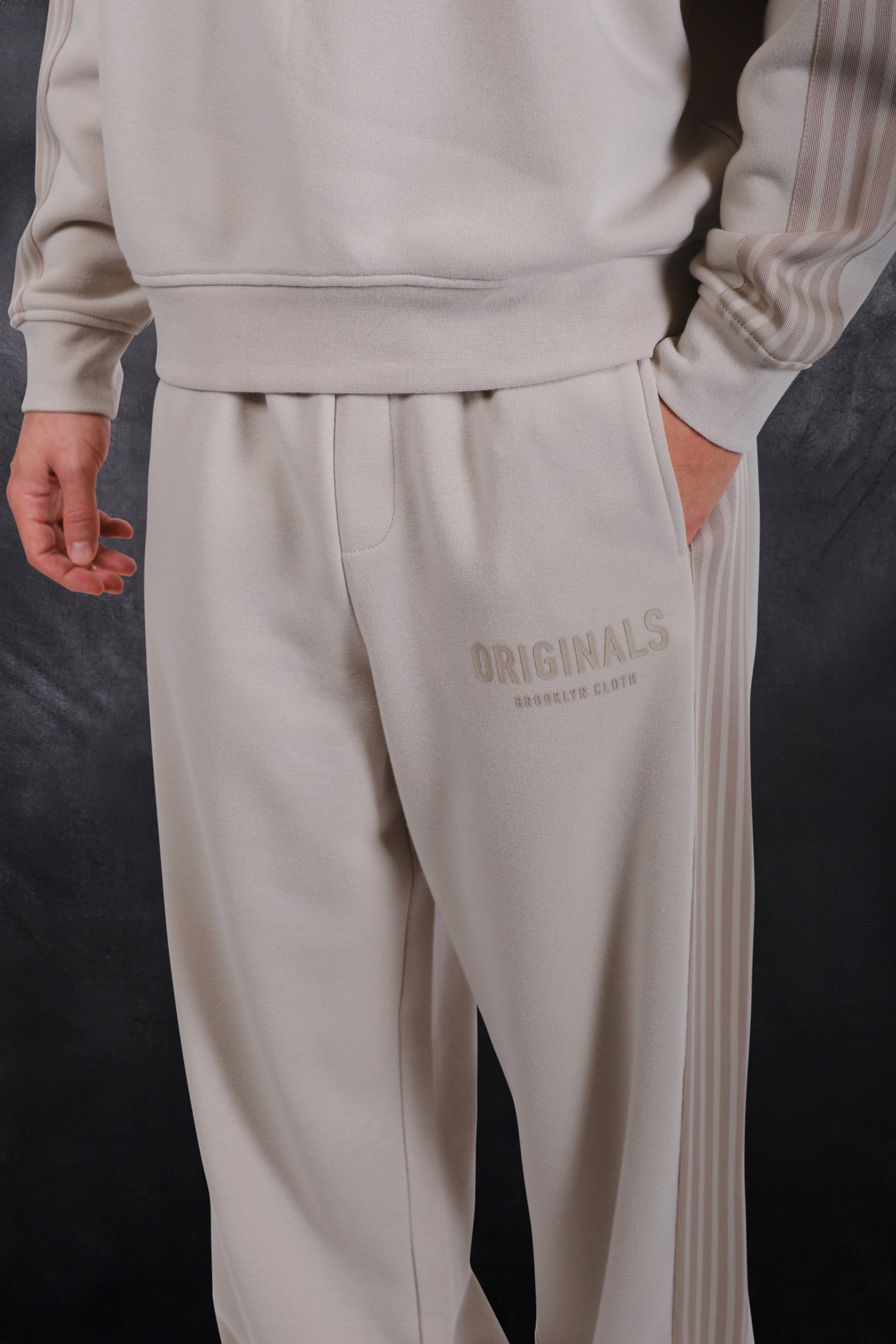 Warm fleece lined track pants with logo on upper left thigh and a drawstring waist #color_sand