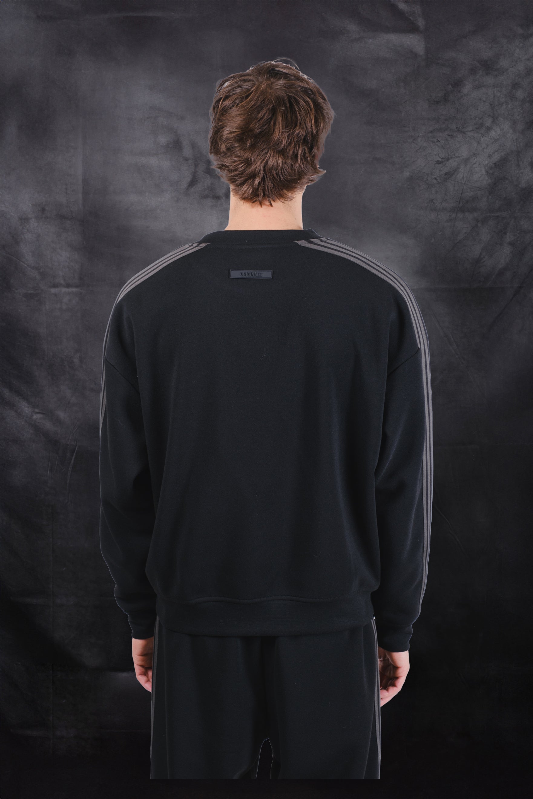 Crewneck track sweatshirt in black with rubber logo patch on back 
#color_black