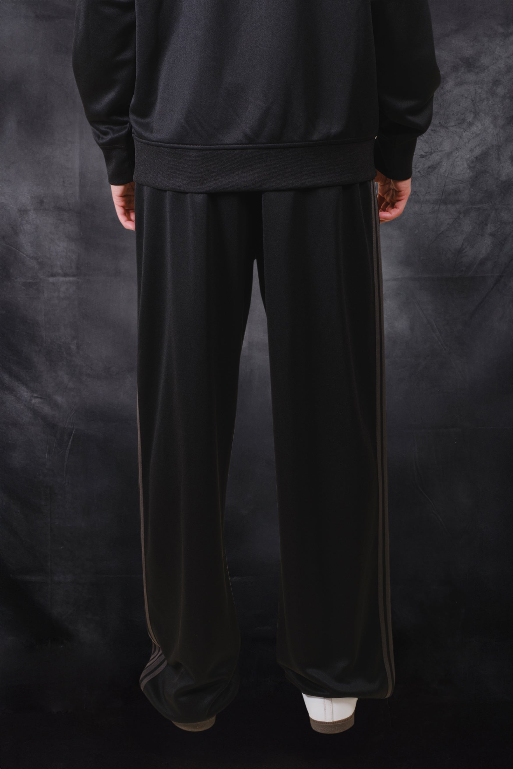 Black pique track pants with a loose fit and drawstring waistband 
#color_black