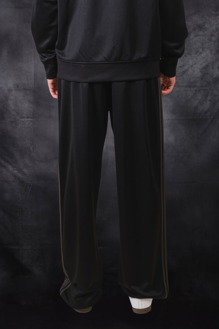 Black pique track pants with a loose fit and drawstring waistband 
#color_black