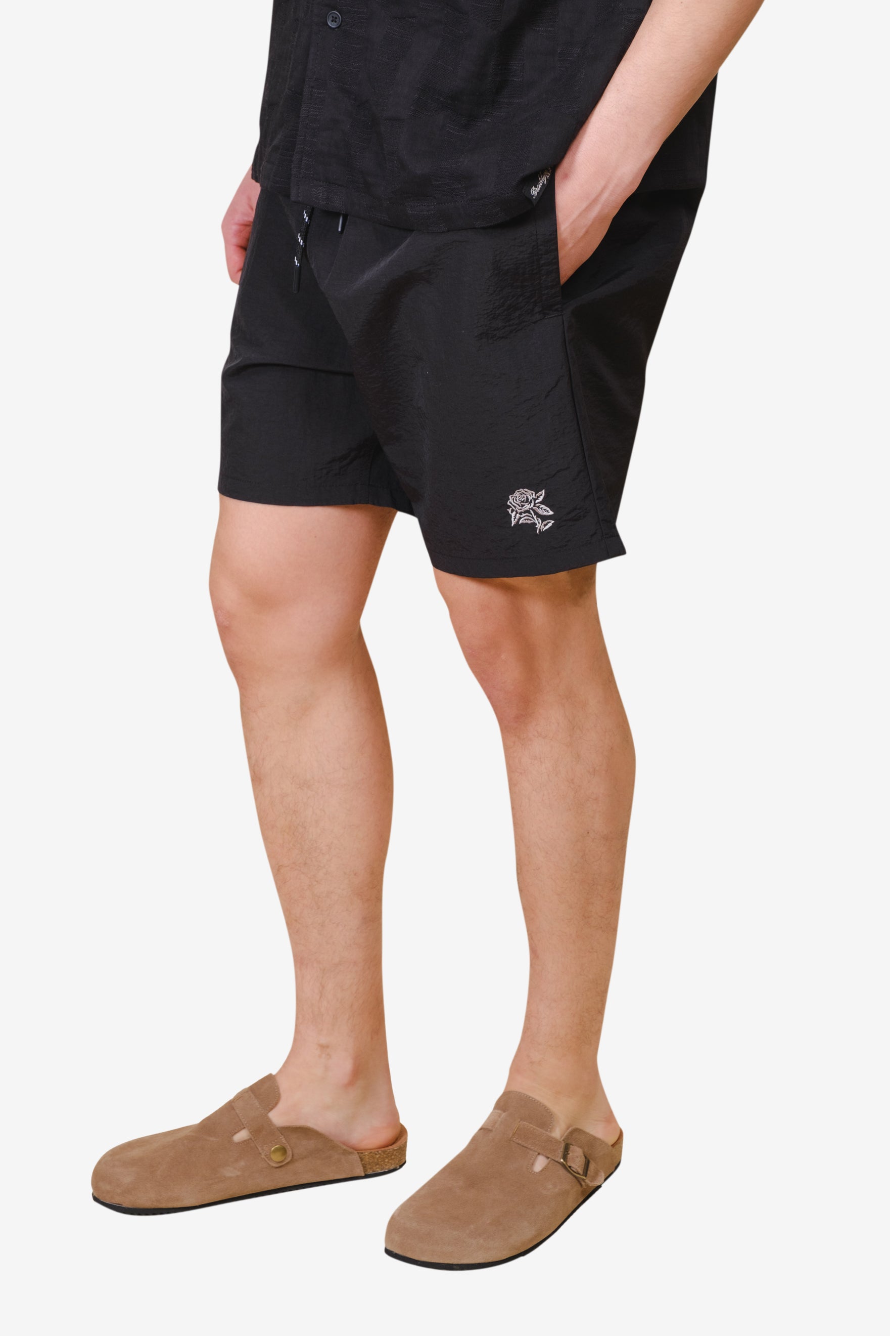 Stylish men's monotone crinkle nylon shorts with a comfortable elastic band and simple flower design 
#color_black