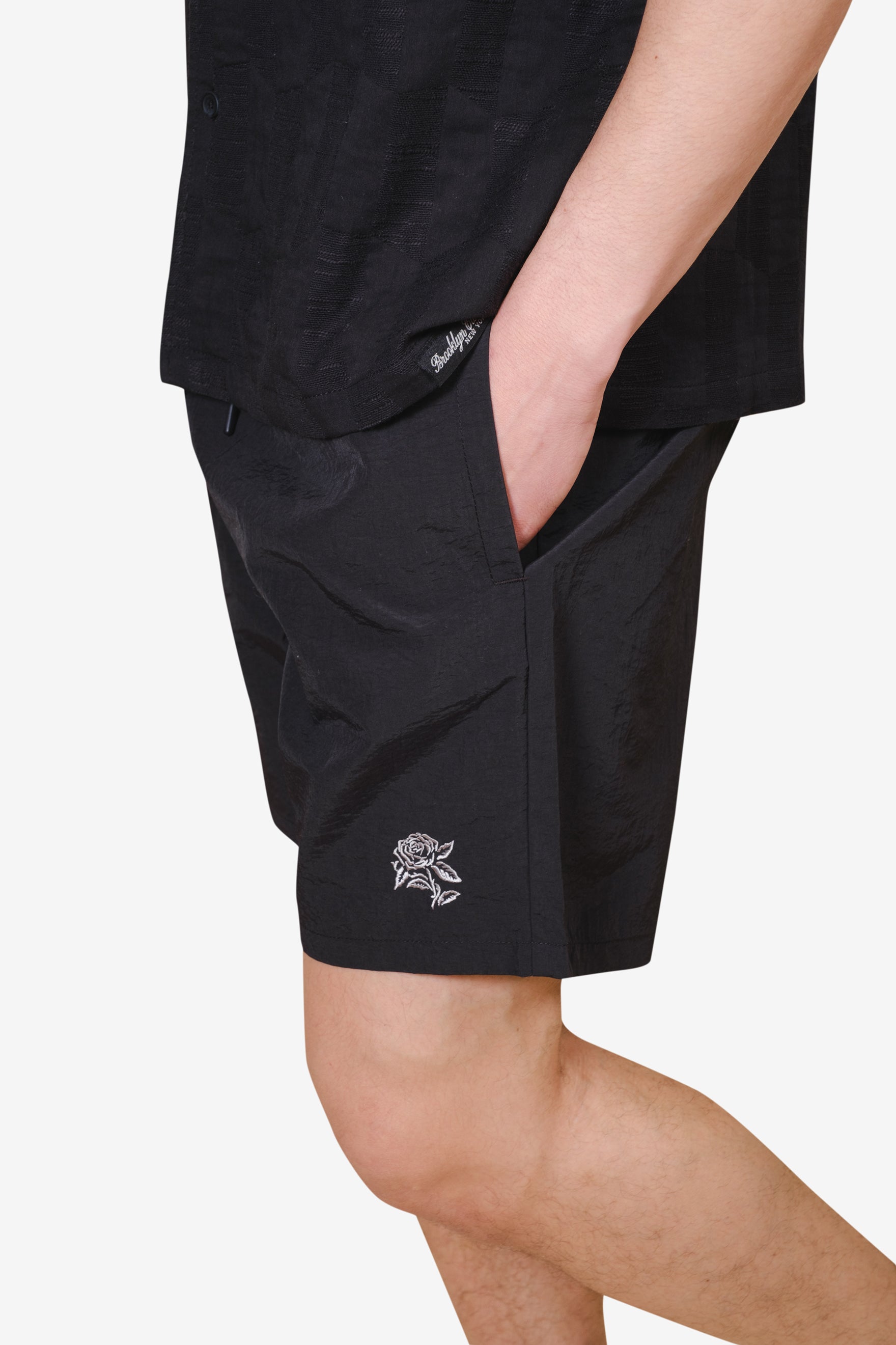 Must have men's monotone crinkle nylon shorts with a stylish waistband and flower on bottom right corner
 #color_black
