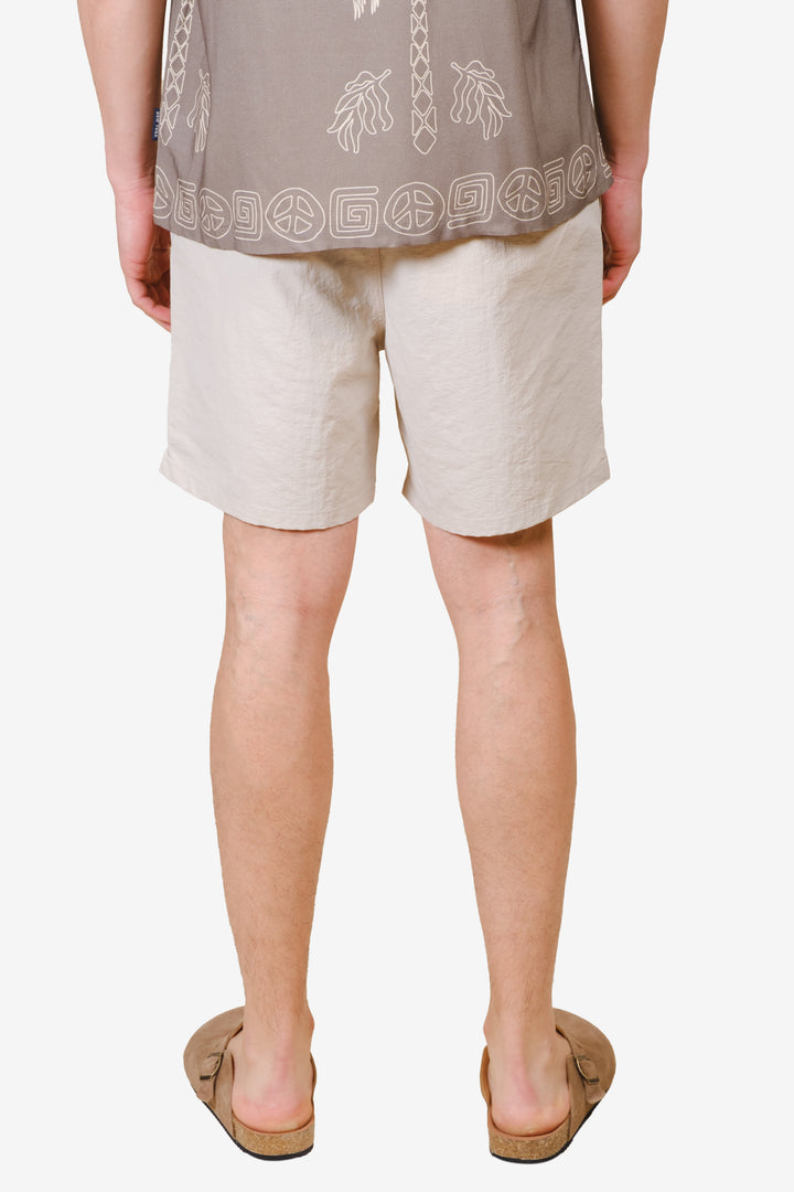 Men's monotone crinkle nylon shorts with flower detailing
#color_sand