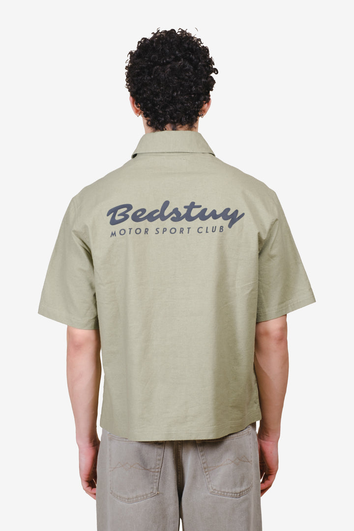 Men's short sleeve cropped button up shirt with writing detail on back 
#color_olive-gray