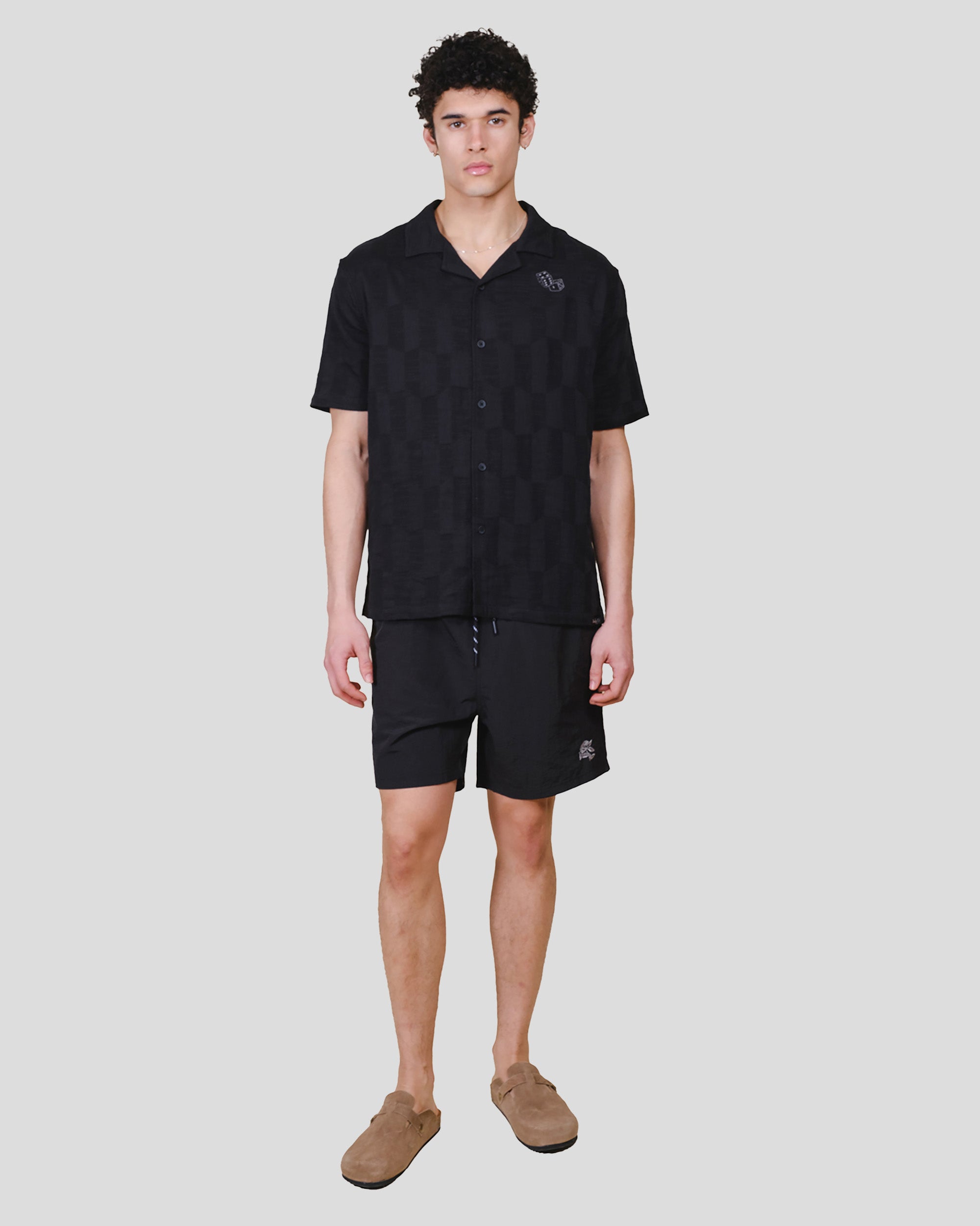 Men's relaxed fit button down woven top with camp collar and dice detail #color_black